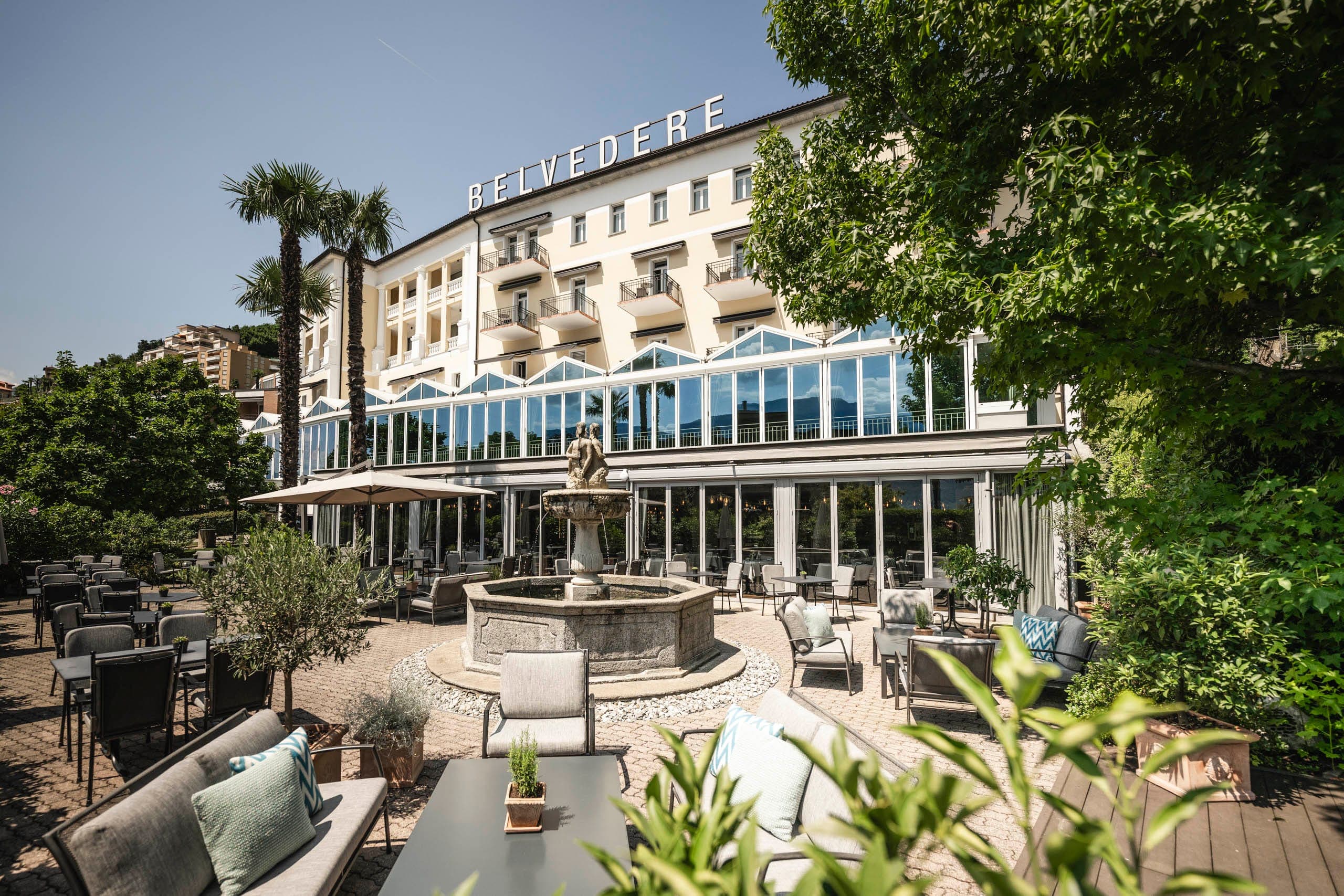 Facciata dell’Hotel Belvedere a Locarno con terrazza giardino e fontana.