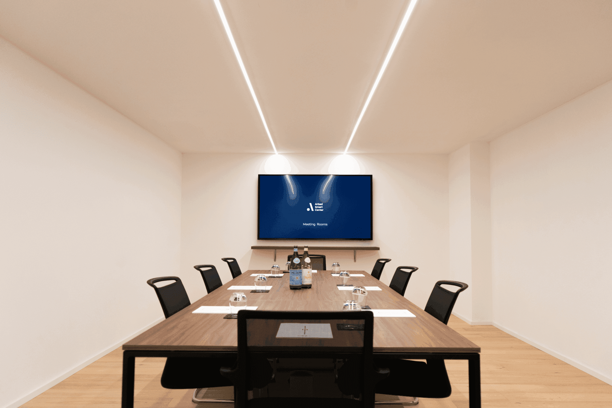 Sala conferenze della Multimmobiliare SA a Locarno con lungo tavolo e schermo a parete.